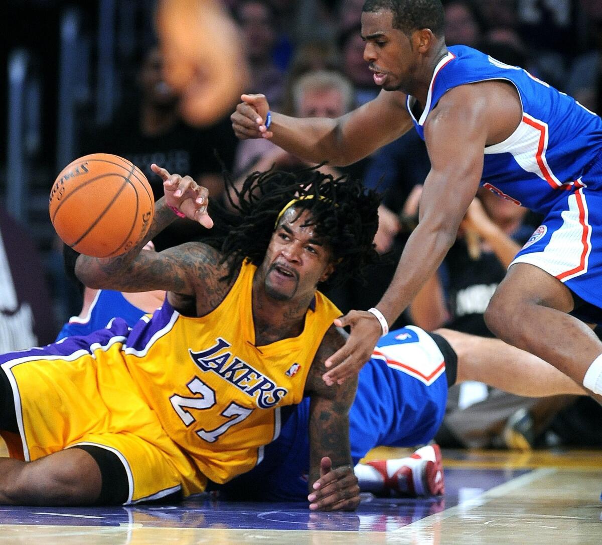 Jordan Hill gets control of a loose ball in front of Chris Paul during the Lakers' 116-103 home-opening win over the Clippers on Tuesday.