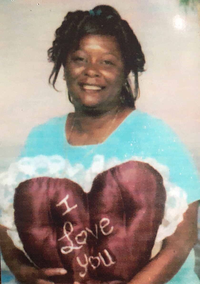 A woman poses for a photo with an "I love you" pillow