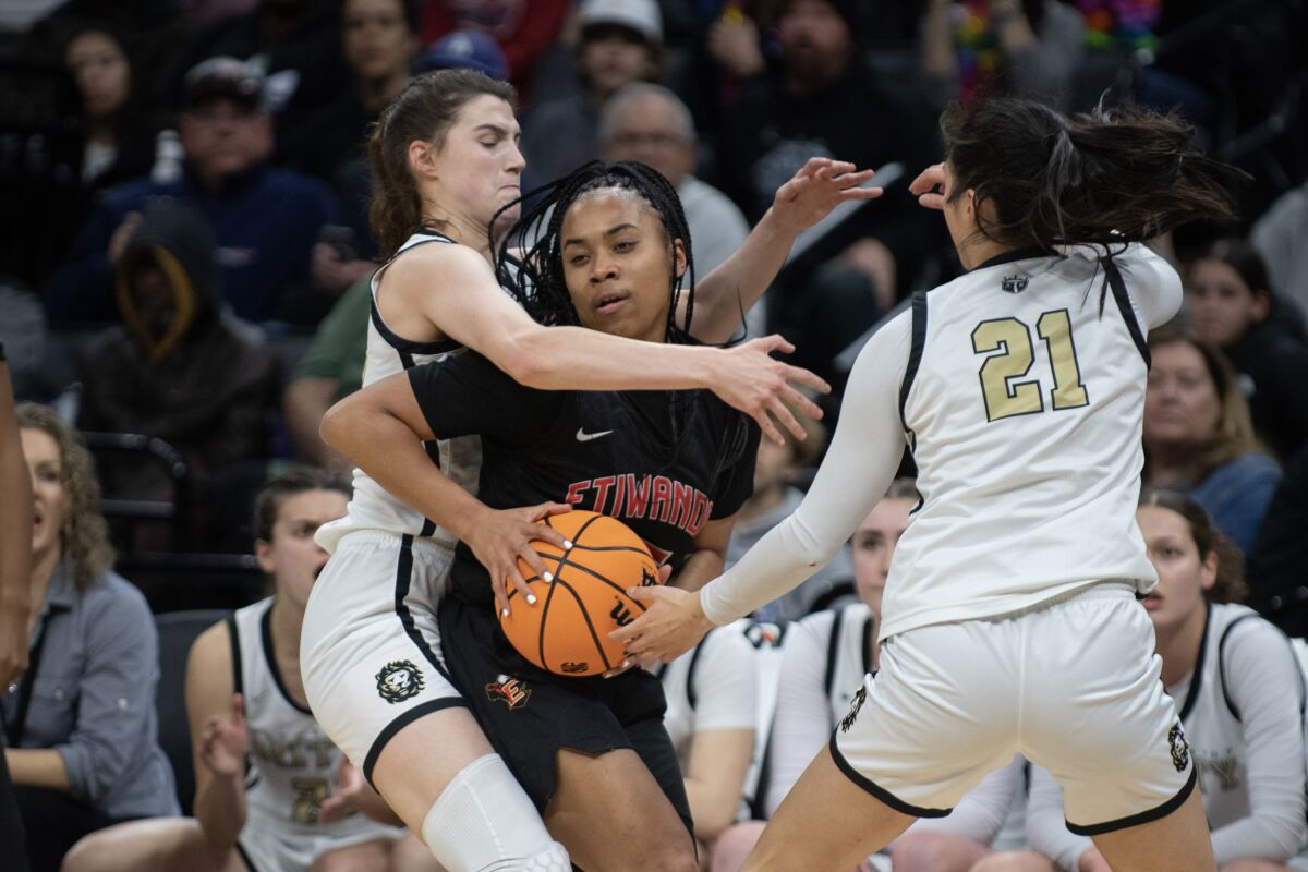 Etiwanda's Aliyahna Morris tries to fight through the double-team defense of Mitty's Morgan Cheli (33) and April Chan (21).