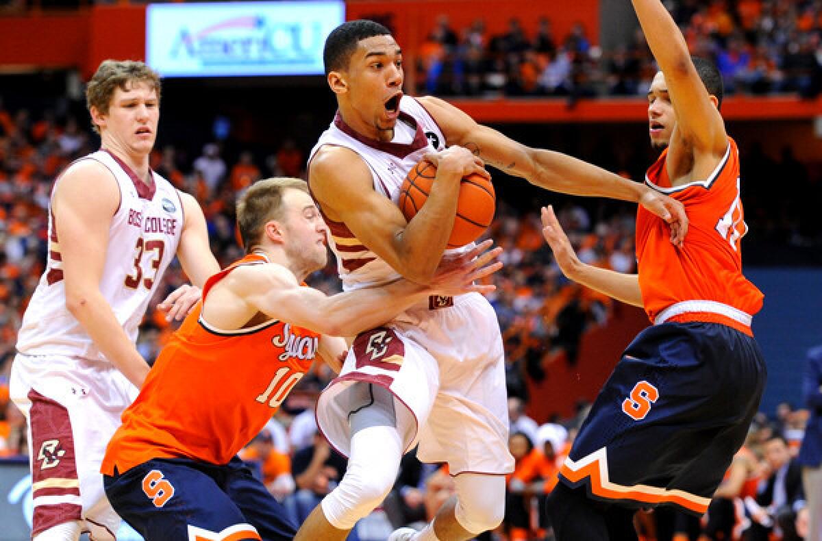 Boston College's Olivier Hanlan tries to split the defense of Syracuse's Trevor Cooney (10) and Tyler Ennis on a drive in the second half of their game Wednesday night at the Carrier Dome.