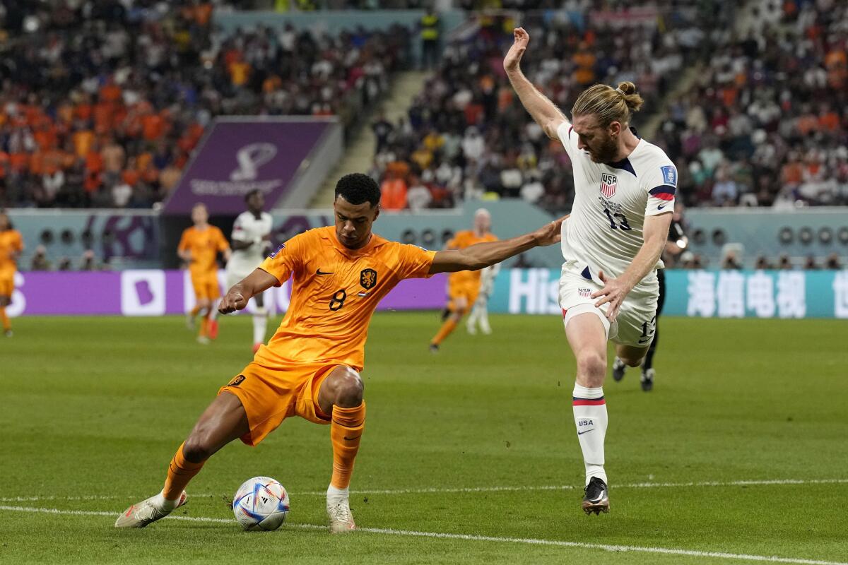 Cody Gakpo of the Netherlands controls the ball while defended by American Tim Ream.