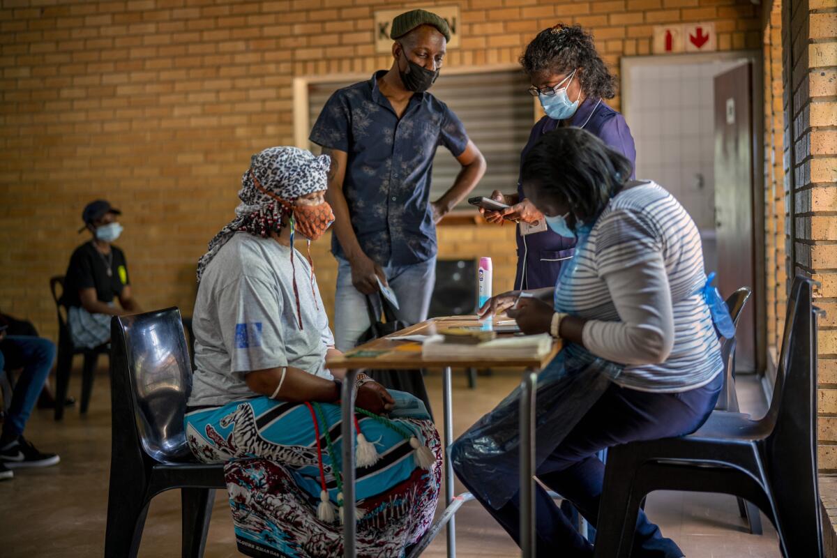 People are processed before receiving their vaccinations against COVID-19 in South Africa.