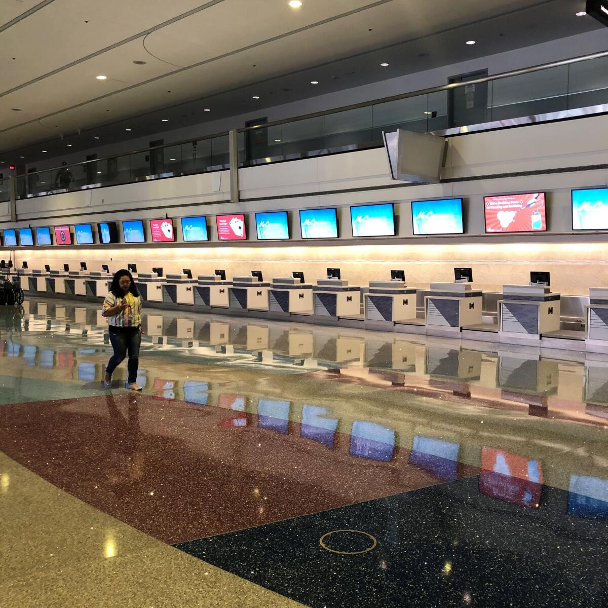 An airport worker walks past empty counters in the Las Vegas airport on June 5.