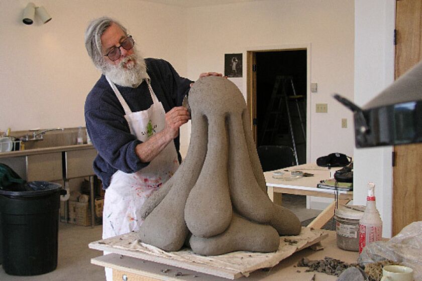 Los Angeles artist Kenneth Price works on a piece. His artwork is often erroneously described as having "transcended" ceramics to become sculpture.