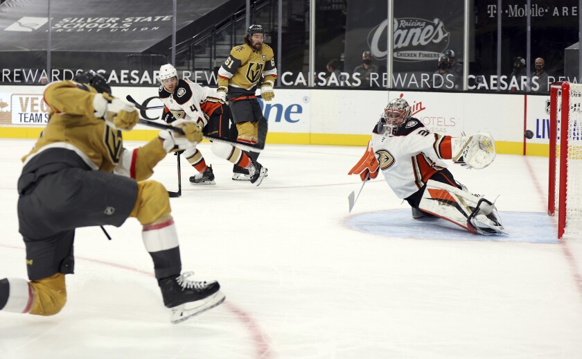 Vegas Golden Knights forward Max Pacioretty, left, shoots and scores in overtime past Ducks goalie Ryan Miller.