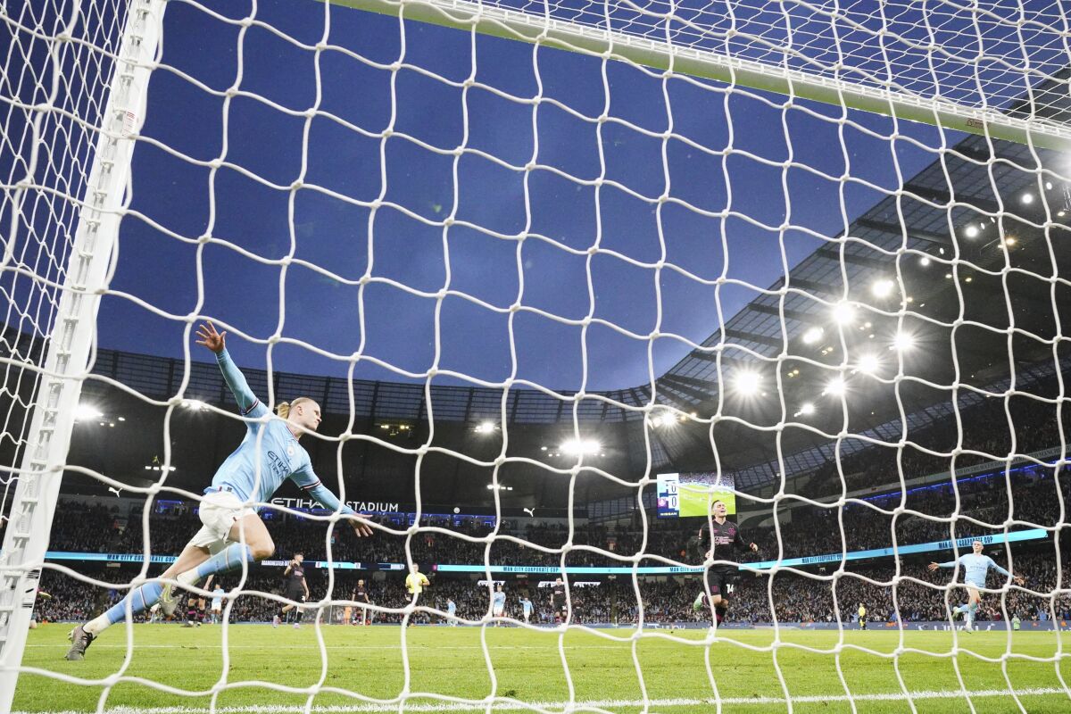 Manchester City's Erling Haaland celebrates after scoring his side's opening goal during the English FA Cup quarter final soccer match between Manchester City and Burnley at the Etihad stadium in Manchester, England, Saturday, March 18, 2023. (AP Photo/Jon Super)
