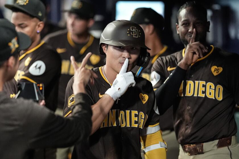 San Diego Padres' Ha-Seong Kim, center, celebrates his solo homer in the seventh inning of a baseball game against the Atlanta Braves, Sunday, May 19, 2024, in Atlanta. (AP Photo/Mike Stewart)