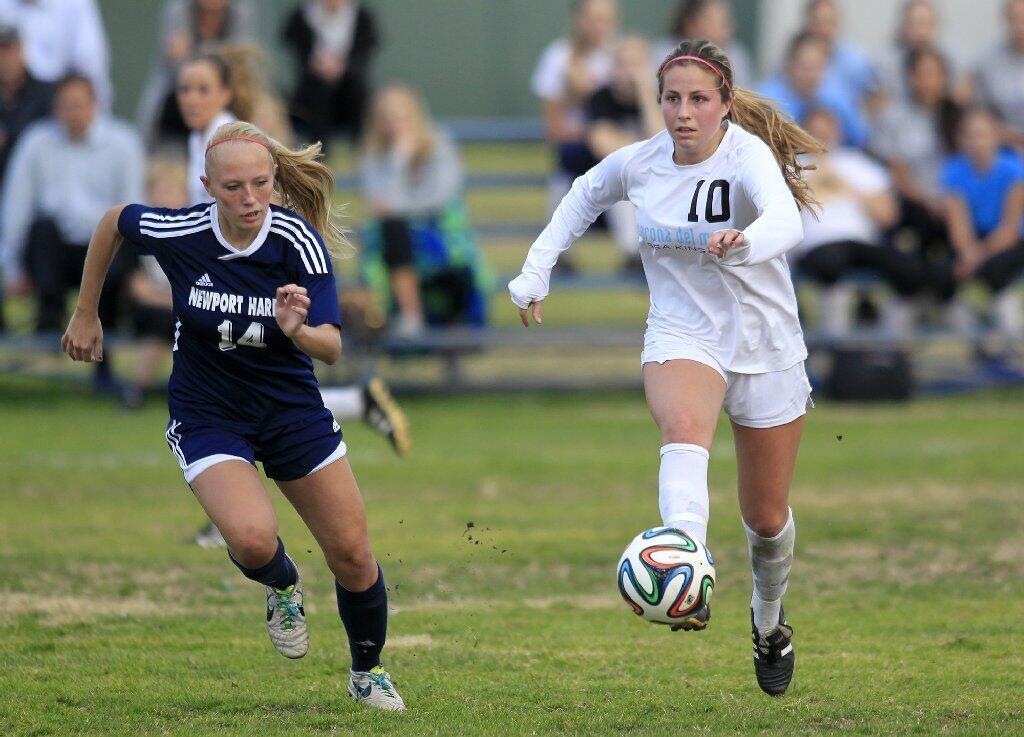 Corona del Mar High's Shelby Brown (10) dribbles the ball against Newport Harbor's Jessica Prather (14) during the second half in the Battle of the Bay match on Tuesday.