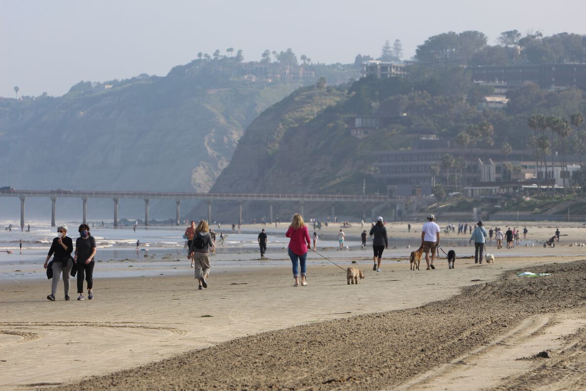 Walkers stroll along La Jolla Shores beach at 7:30 a.m. April 27 after the beach was reopened following a closure due to coronavirus restrictions.