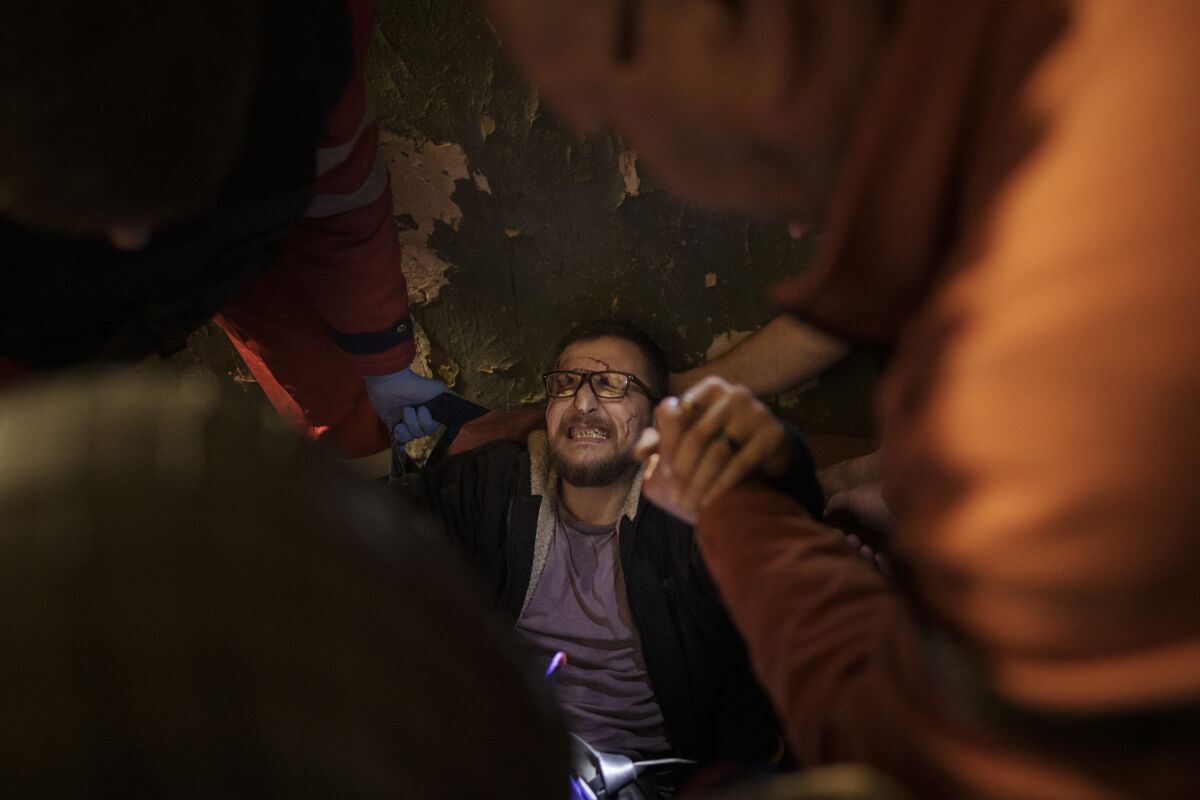 Vadim Krikun is treated in the hallway of his apartment building after a Russian attack in Kharkiv, Ukraine, Friday, April 15, 2022. (AP Photo/Felipe Dana)