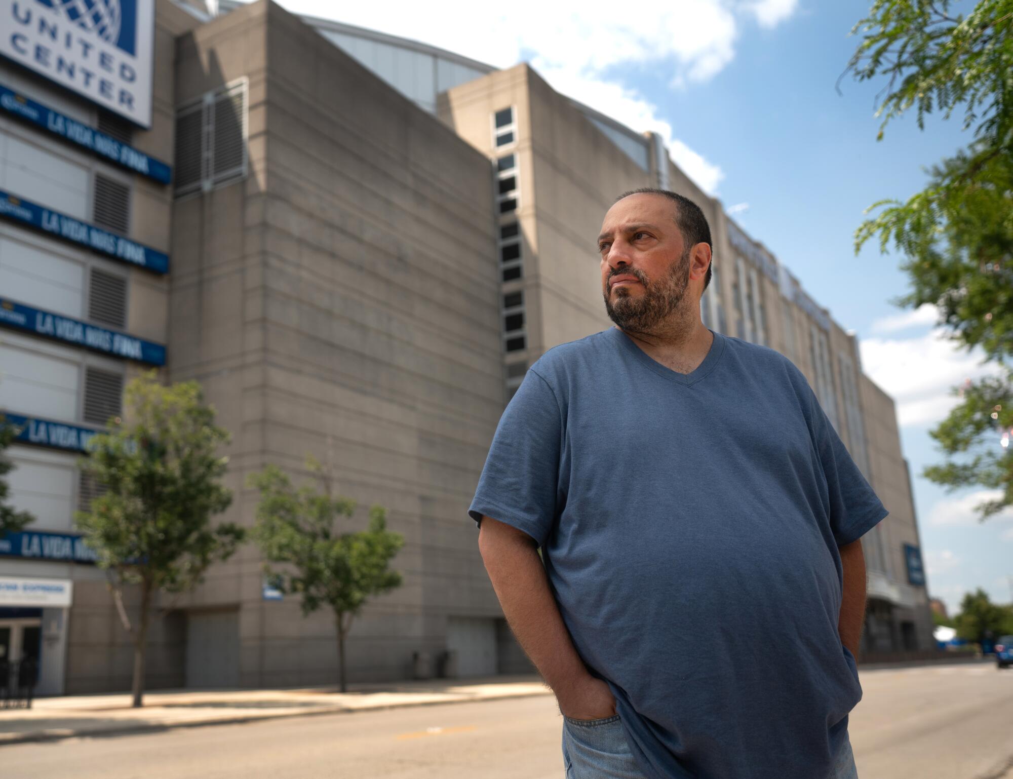 A man in a blue T-shirt stands outside the United Center in Chicago