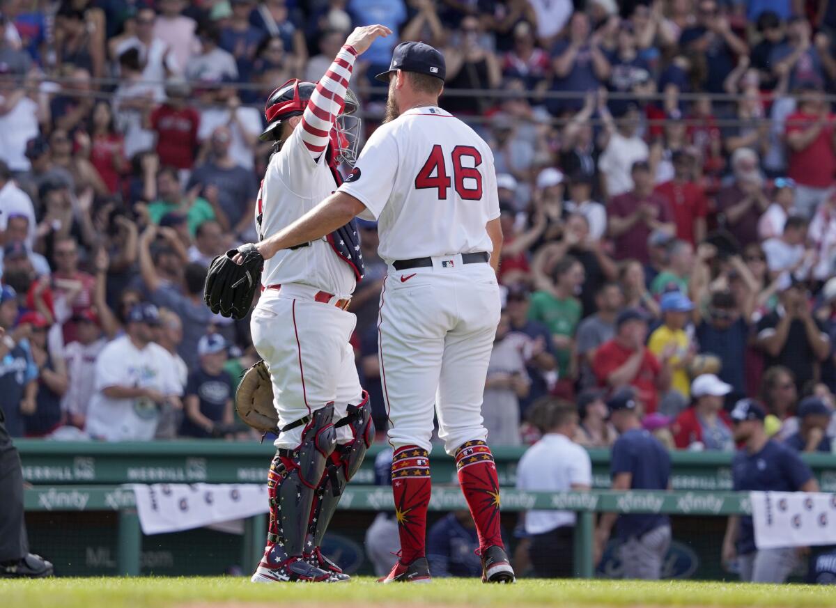 Boston Red Sox relief pitcher John Schreiber (46) is congratulated by Christian Vazquez after closing out the ninth inning of a baseball game against the Tampa Bay Rays at Fenway Park, Monday, July 4, 2022, in Boston. (AP Photo/Mary Schwalm)