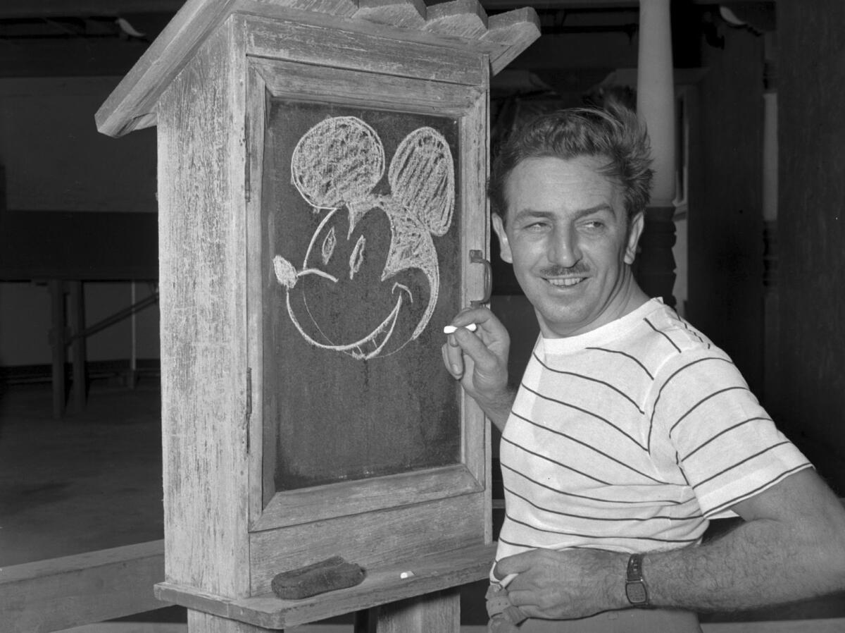 Walt Disney draws Mickey Mouse on a chalk board.