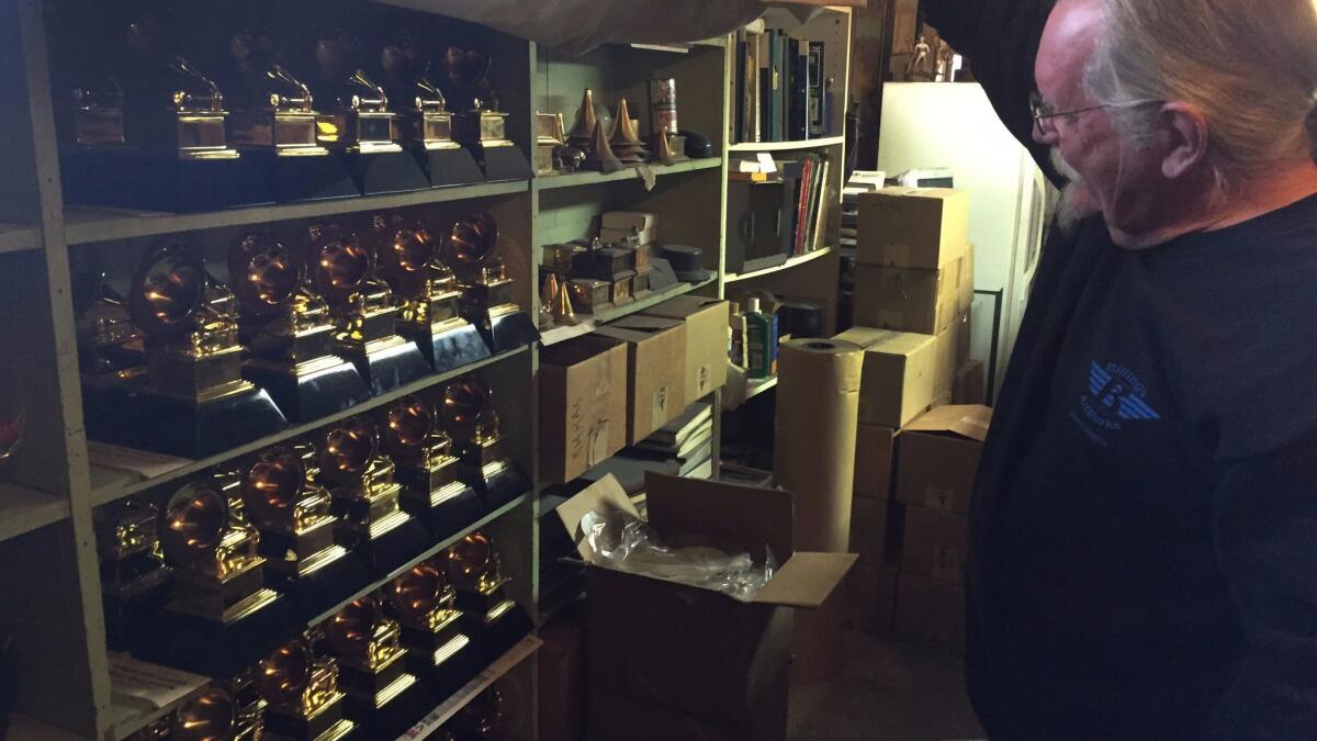 Billings lifts a curtain to reveal shelves of so-called "stunt Grammys," which are given to the artists the night of the ceremony and then taken back. The real ones are engraved here and then driven to Los Angeles by Billings.