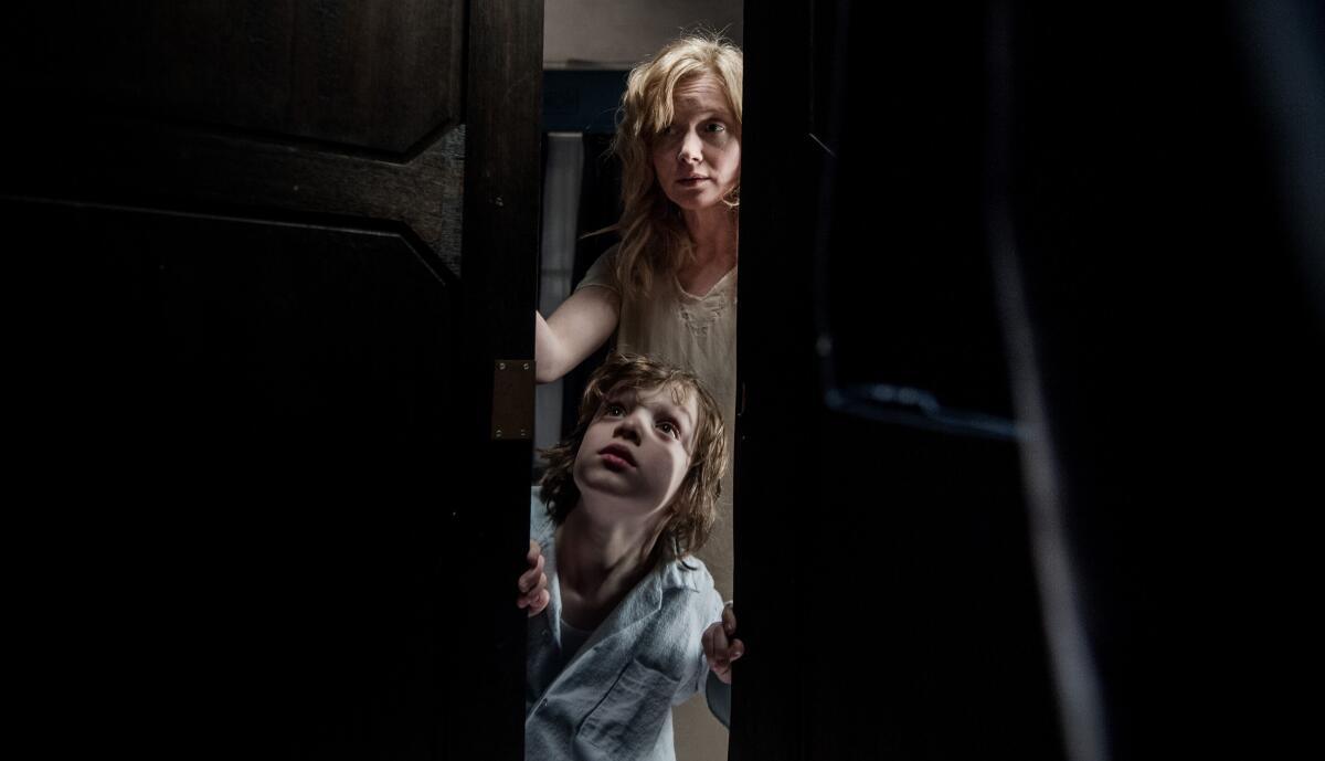 A mom and son look in a closet for monsters.