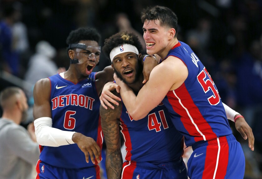 Detroit Pistons forward Saddiq Bey (41) celebrates with guard Hamidou Diallo (6) and center Luka Garza, right, after sinking a three-point shot to defeat the San Antonio Spurs during overtime of an NBA basketball game Saturday, Jan. 1, 2022, in Detroit. (AP Photo/Duane Burleson)