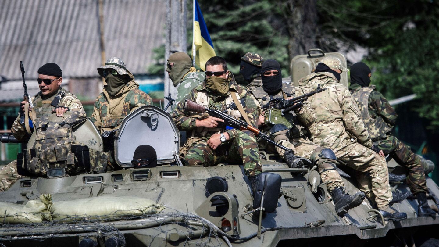 Ukrainian soldiers stand guard atop an armored personnel carrier in the town of Volnovakha.