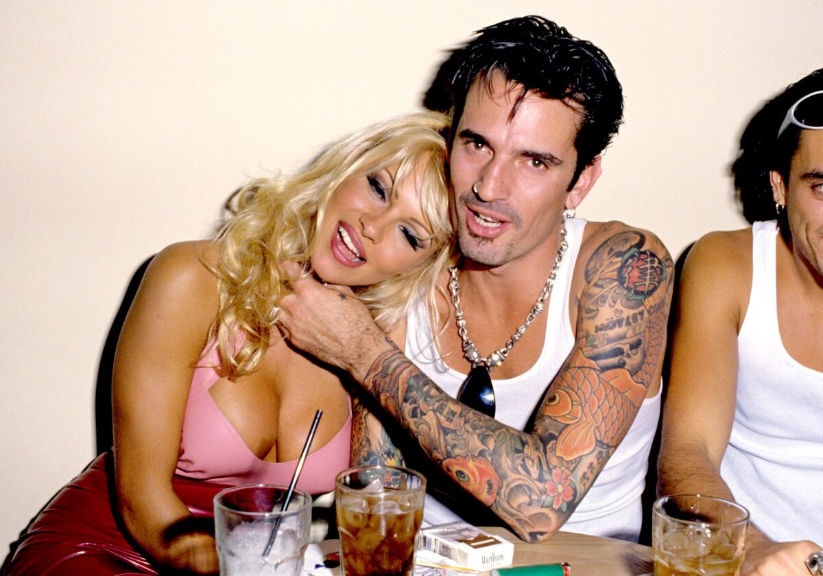 A blond woman and a tattooed man.