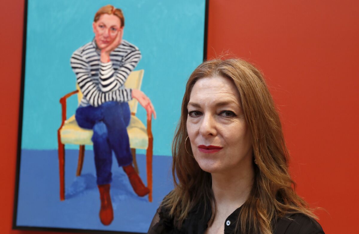 Edith Devaney beside her portrait in "David Hockney: 82 Portraits and 1 Still-life” at LACMA. (Luis Sinco / Los Angeles Times)