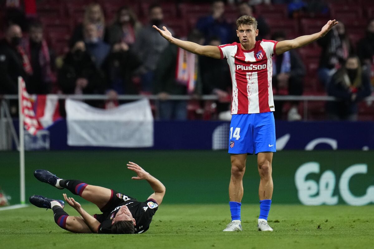 Atletico Madrid's Marcos Llorente reacts after a tackle with Levante's Pepelu, on the ground, during a Spanish La Liga soccer match between Atletico Madrid and Levante at the Wanda Metropolitano stadium in Madrid, Spain, Wednesday, Feb. 16, 2022. (AP Photo/Manu Fernandez)