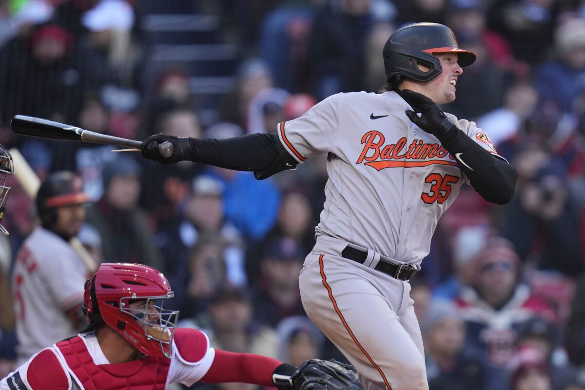 Baltimore Orioles' Adley Rutschman watches the flight of his RBI single in the seventh inning of an opening day baseball game against the Boston Red Sox at Fenway Park, Thursday, March 30, 2023, in Boston. (AP Photo/Charles Krupa)