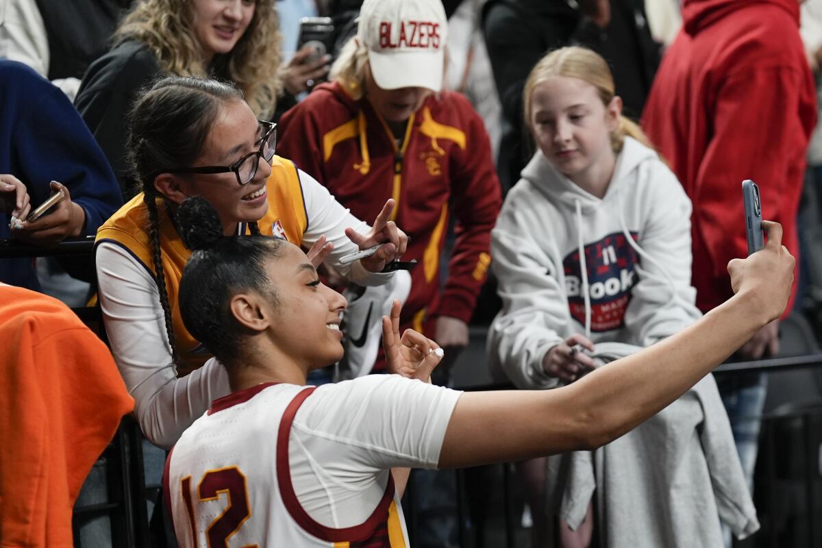 USC guard JuJu Watkins poses for a photo with a fan after the Sweet 16 win over Baylor on Saturday.