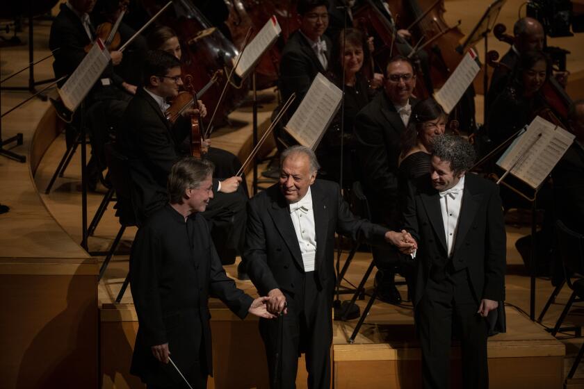 LOS ANGELES, CA OCTOBER 24, 2019: Esa-Pekka Salonen, left, Zubin Mehta, middle, and Gustavo Dudamel, right, take a bow. On its 100th birthday, the LA Phil holds a gala concert at the Walt Disney Concert Hall October 24, 2019. The event includes its three living music directors -- Zubin Mehta, Esa-Pekka Salonen and Gustavo Dudamel -- performing the premiere of Icelandic composer Daniel Bjarnason’s “From Space I saw Earth,” for three conductors, written for the occasion. (Francine Orr/ Los Angeles Times)