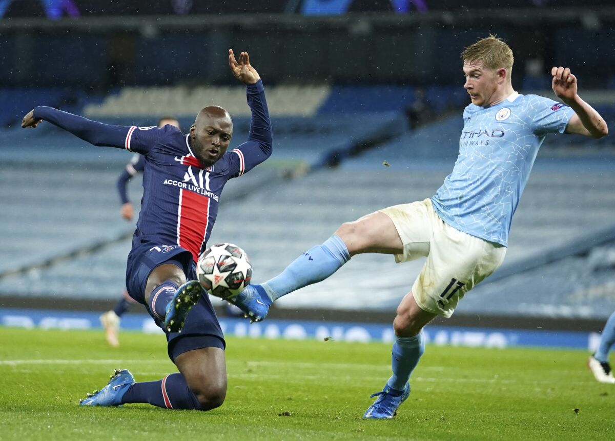 PSG's Danilo Pereira, left, challenges Manchester City's Kevin De Bruyne during the Champions League semifinal second leg soccer match between Manchester City and Paris Saint Germain at the Etihad stadium, in Manchester, Tuesday, May 4, 2021. (AP Photo/Dave Thompson)