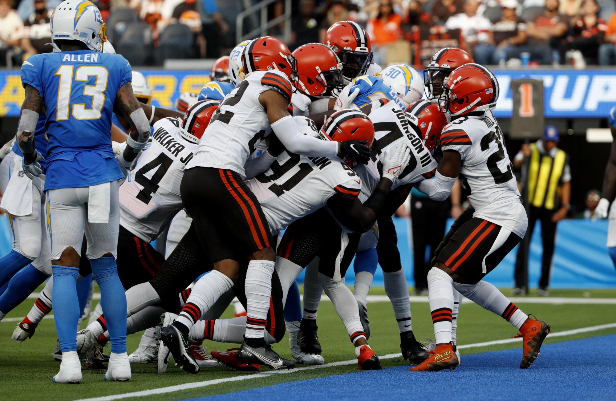 Chargers running back Austin Ekeler is pulled and pushed into the end zone by the Cleveland Browns.