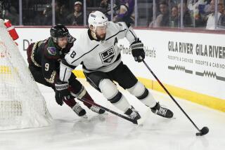 Los Angeles Kings defenseman Drew Doughty (8) shields the puck from Arizona Coyotes.