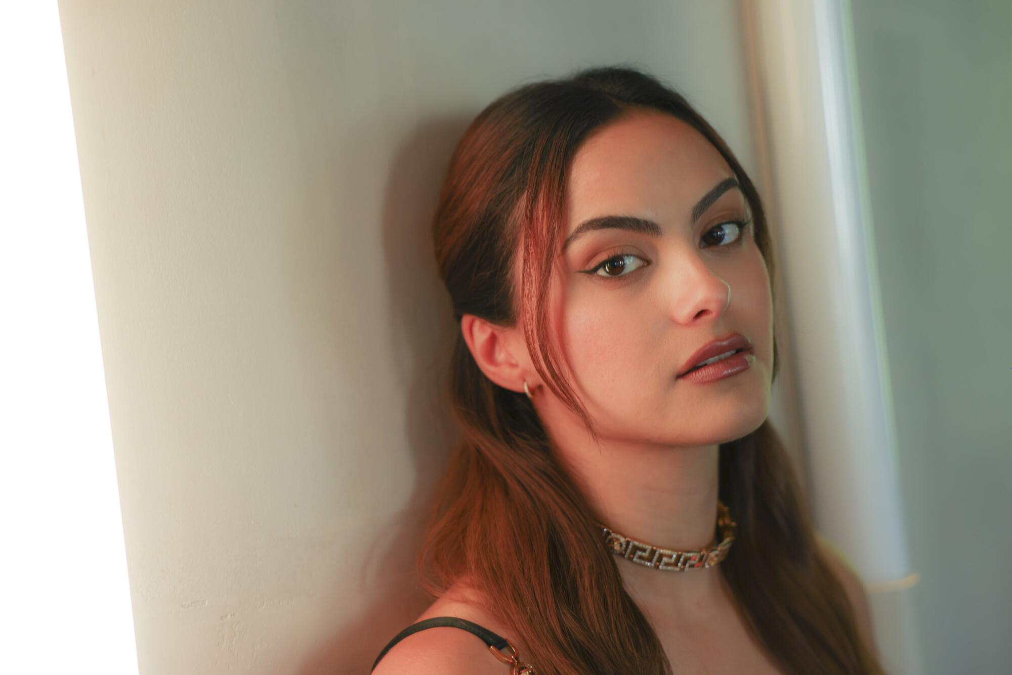 A woman leaning against a wall.