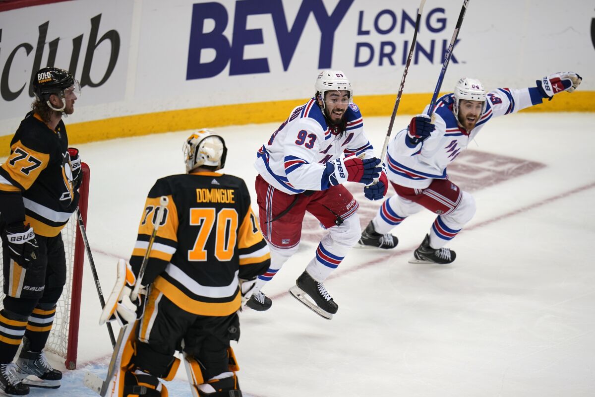 New York Rangers' Mika Zibanejad (93) and Tyler Motte (64) begin the celebrate the winning goal by Chris Kreider (not shown) during the third period in Game 6 of an NHL hockey Stanley Cup first-round playoff series against the Pittsburgh Penguins in Pittsburgh, Friday, May 13, 2022. (AP Photo/Gene J. Puskar)