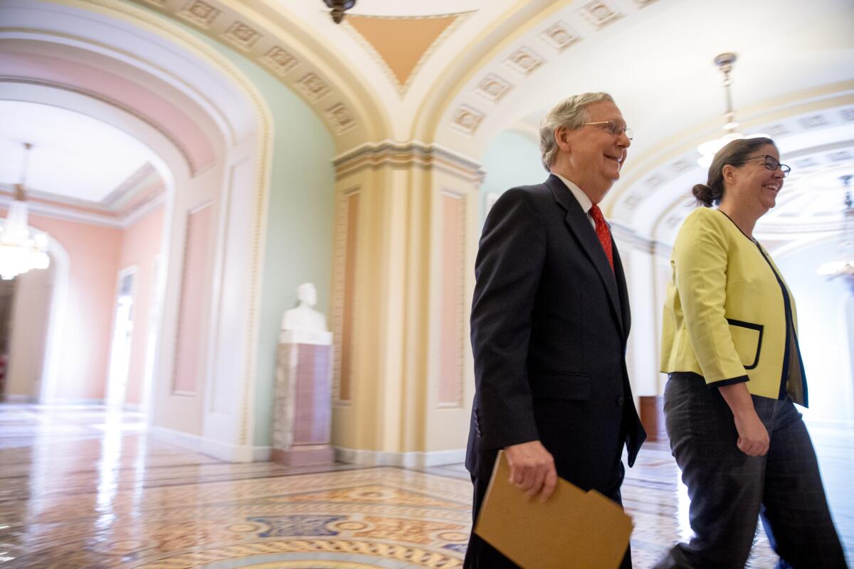 Senate Majority Leader Mitch McConnell, left, accompanied by Secretary for the Majority of the Senate Laura Dove, heads into the Senate chamber for a Sunday session on Capitol Hill in Washington, July 26, 2015.