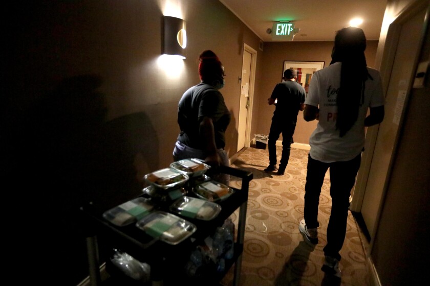 Mia Rogers, 23, left, delivers lunches to guests at an L.A. hotel participating Project Roomkey on July 22. 
