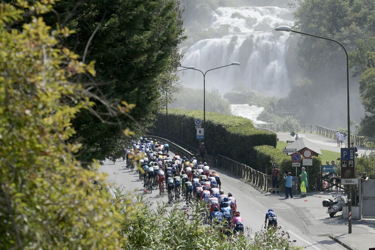 The pack of cyclists ride past the Marmore Waterfalls during the fourth stage of the Tirreno Adriatico cycling race, from Terni to Cascia, Italy, Thursday, Sept. 10, 2020. (Marco Alpozzi/LaPresse via AP)