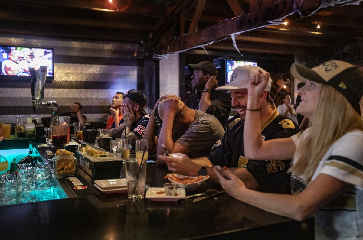 New Orleans Saints fans react with joy as Chicago Bears fans react with dejection.