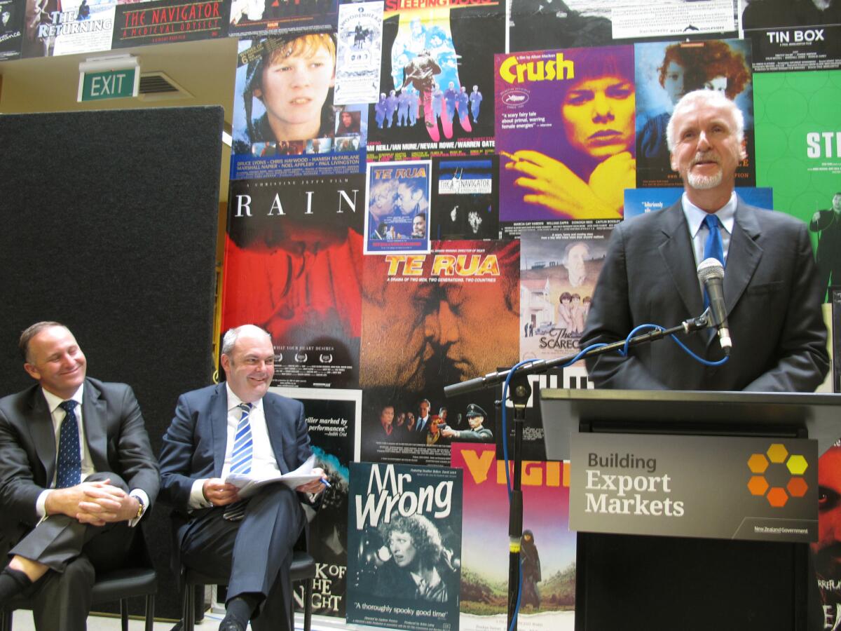 New Zealand Prime Minister John Key, left, and Economic Development Minister Steven Joyce listen as director James Cameron announces details about three sequels to his 2009 blockbuster sci-fi movie "Avatar."