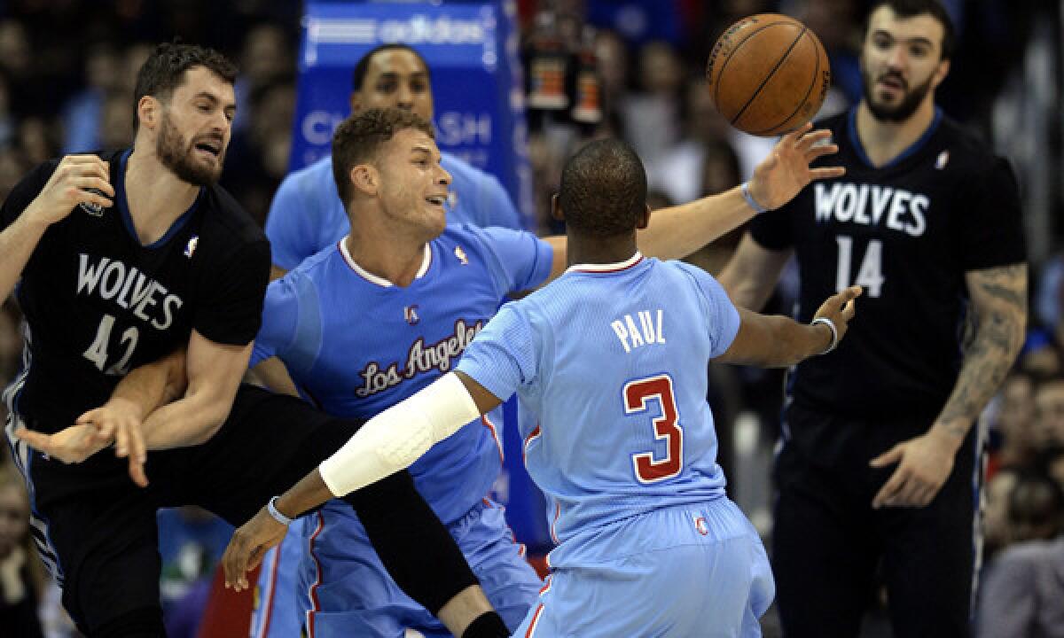 Clippers teammates Blake Griffin, middle left, and Chris Paul, middle right, battle for a rebound against Minnesota's Kevin Love, left, and Nikola Pekovic during the Clippers' 120-116 overtime win on Dec. 22.