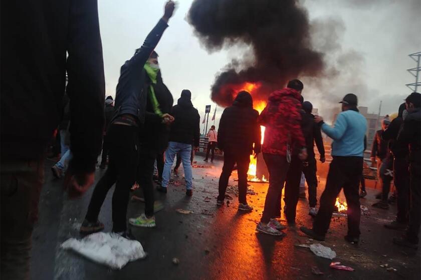 Iranian protesters gather around a fire during a demonstration against an increase in gasoline prices in the capital Tehran, on November 16, 2019. - One person was killed and others injured in protests across Iran, hours after a surprise decision to increase petrol prices by 50 percent for the first 60 litres and 300 percent for anything above that each month, and impose rationing.