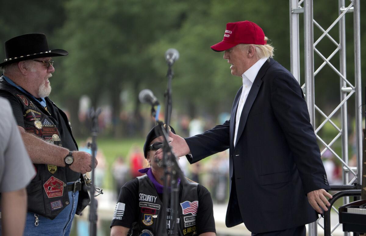 Donald Trump, derecha, el virtual candidato republicano a la presidencia, saluda a sus partidarios y a motociclistas en un mitin de la organización Rolling Thunder en el National Mall en Washington, el domingo 29 de mayo de 2016.