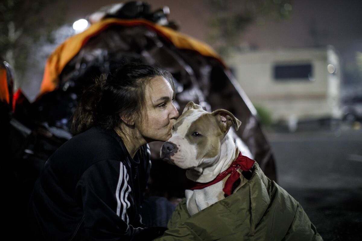 Brenda Wilson, who had just moved to Magalia from Chico before the Camp fire, kisses her dog Scooby at the Chico evacuation center. (Marcus Yam / Los Angeles Times)