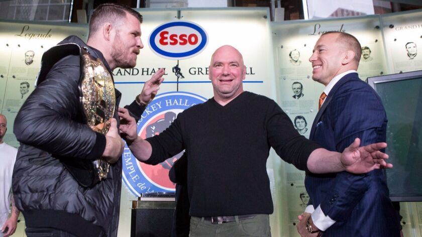 UFC President Dana White separates Michael Bisping, left, and Georges St-Pierre during a news conference to promote their UFC 217 fight in Toronto on Oct. 13.
