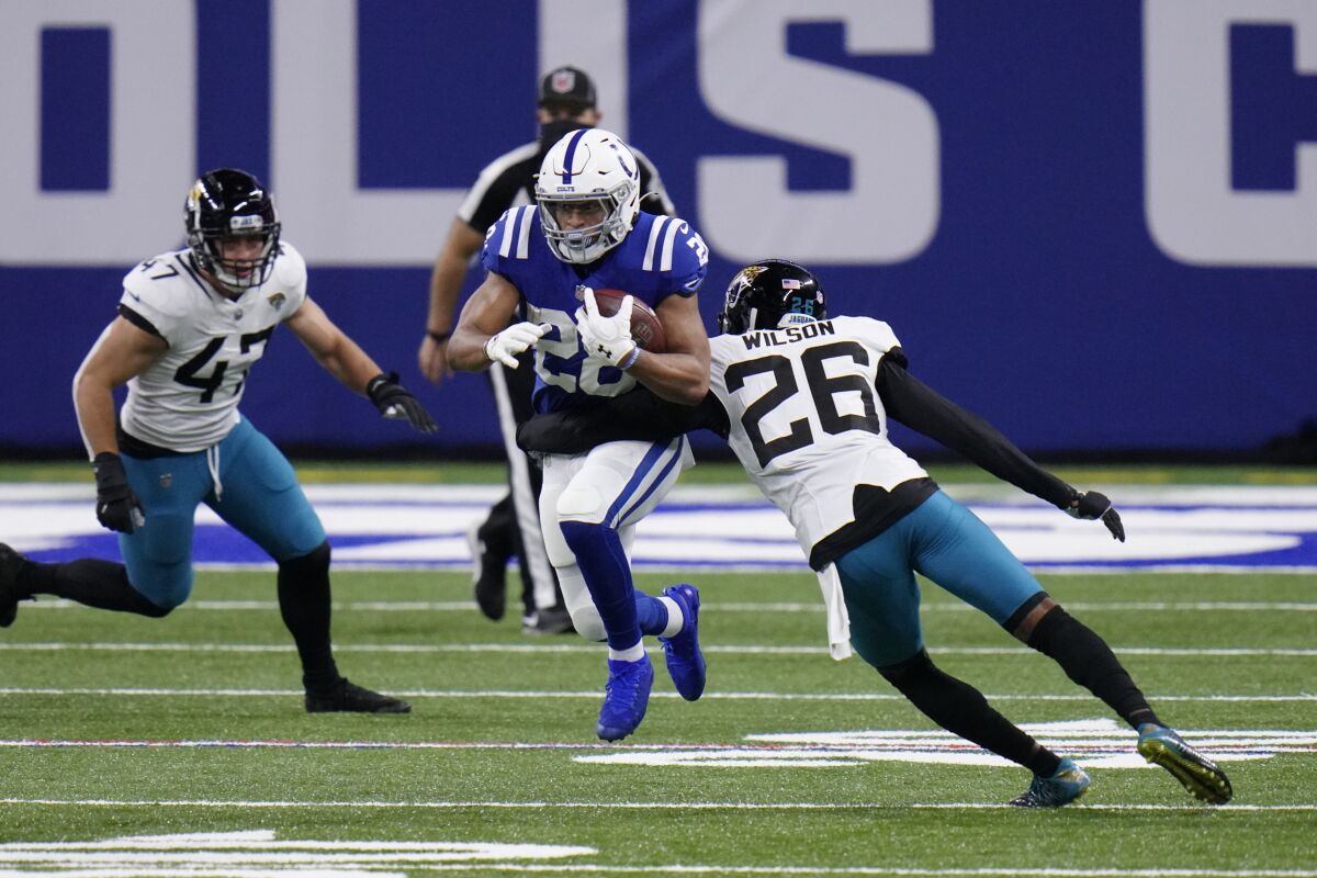 Indianapolis Colts' Jonathan Taylor (28) runs past Jacksonville Jaguars' Jarrod Wilson (26) during the first half of an NFL football game, Sunday, Jan. 3, 2021, in Indianapolis. (AP Photo/AJ Mast)