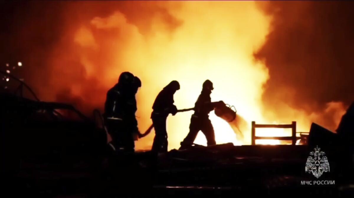Silhouettes of firefighters trying to extinguish a blaze