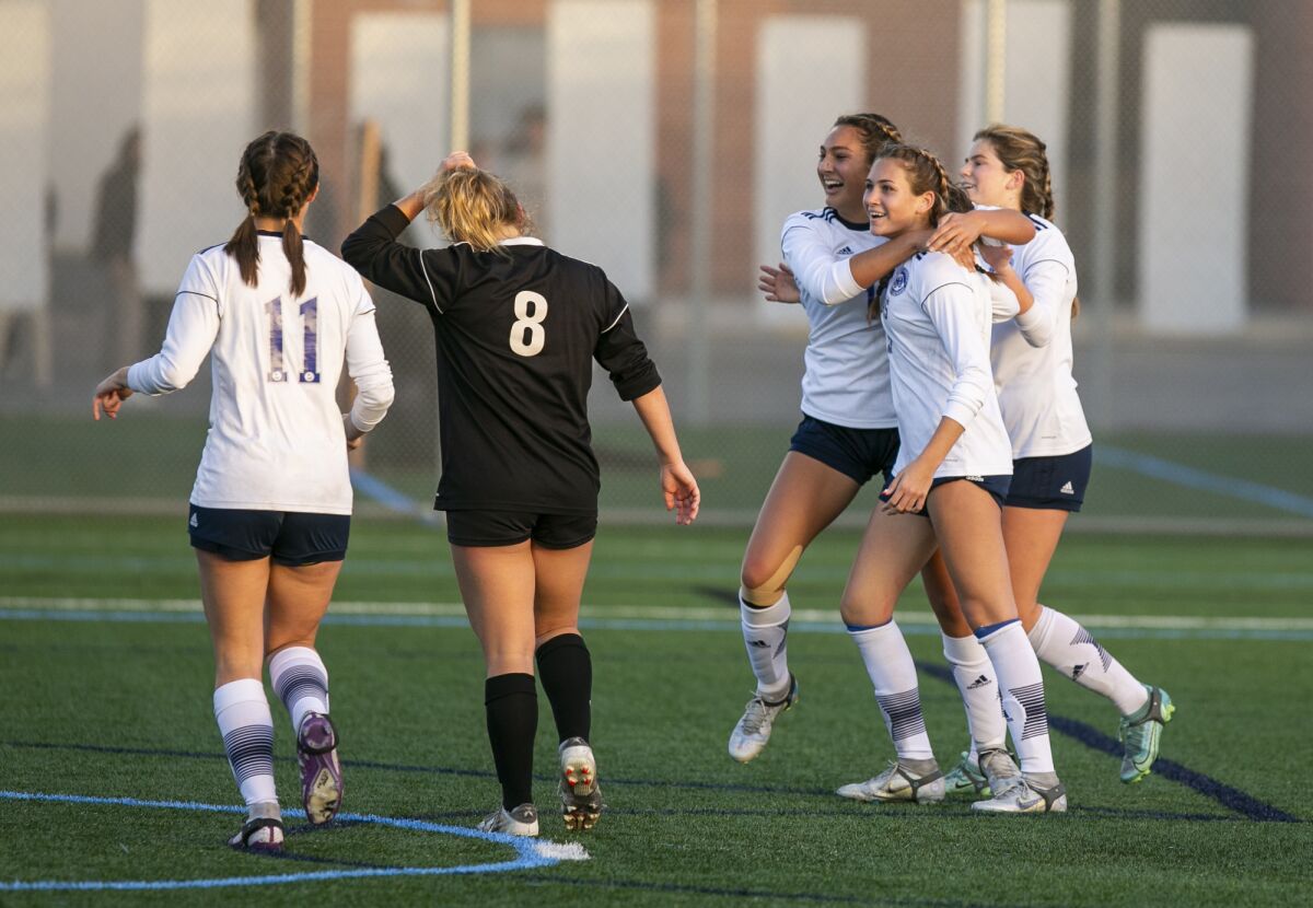 Newport Harbor's Sadie Hoch, center right, is hugged by Kylie Lopez and Sammy Forbath after scoring against Corona del Mar.