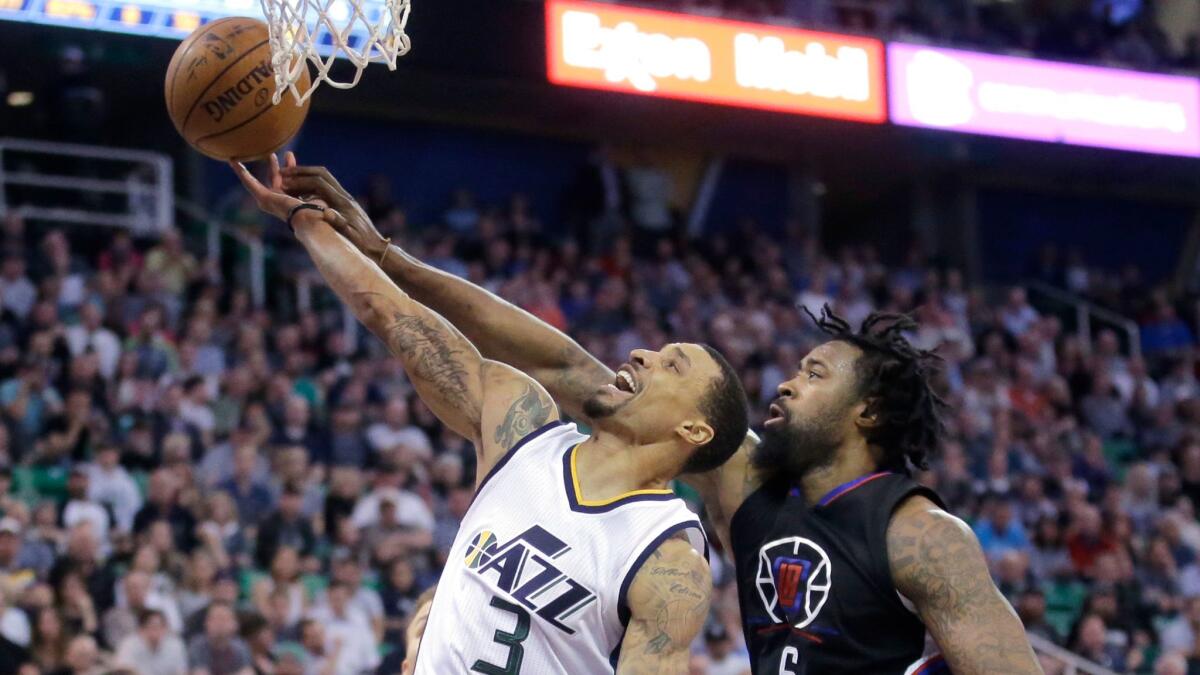 Clippers center DeAndre Jordan, right, fouls Utah guard George Hill as he goes to the basket on March 13.