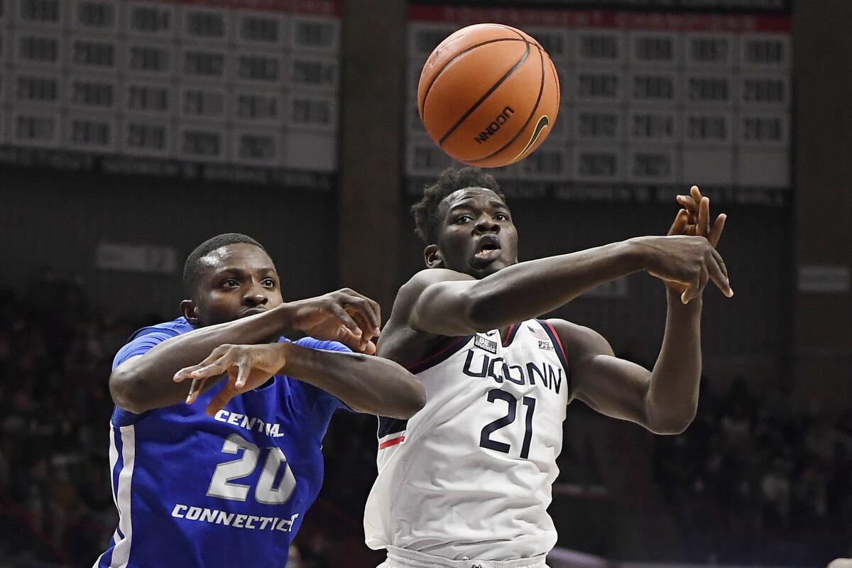 Central Connecticut State's Stephane Ayangma, left, and Connecticut's Adama Sanogo reach for the ball in the second half of an NCAA college basketball game, Tuesday, Nov. 9, 2021, in Storrs, Conn. (AP Photo/Jessica Hill)