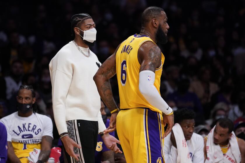 Los Angeles Lakers' Anthony Davis, left, talks with forward LeBron James (6) during the first half of an NBA basketball game against the Indiana Pacers in Los Angeles, Wednesday, Jan. 19, 2022. (AP Photo/Ashley Landis)