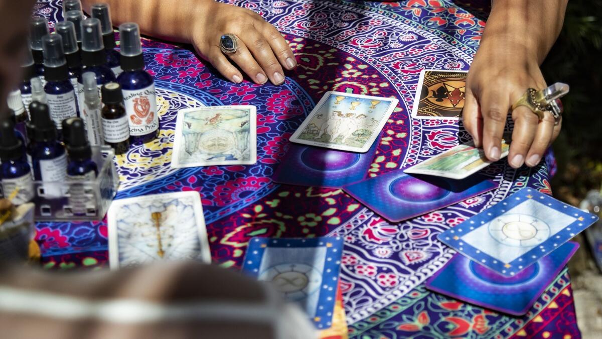 Reina Prado reads tarot cards for a customer during a summer pop-up event at Mostly Angels L.A. with crystal vendors, sound meditation, group cleansing and a day of healing.