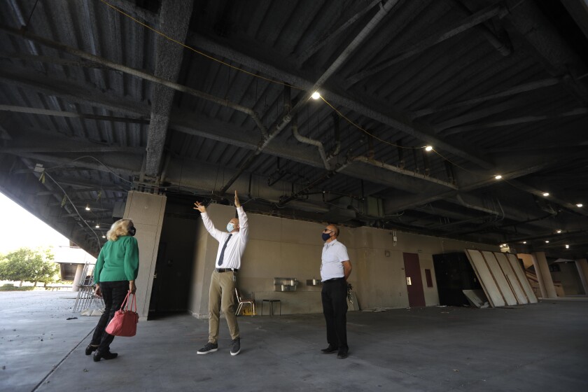 Lynwood School officials stand in outside covered area and inspect the structure.